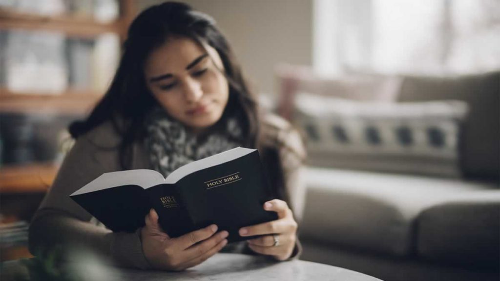 Mulher lendo a Bíblia Sagrada e meditando nos versículos bíblicos preciosos