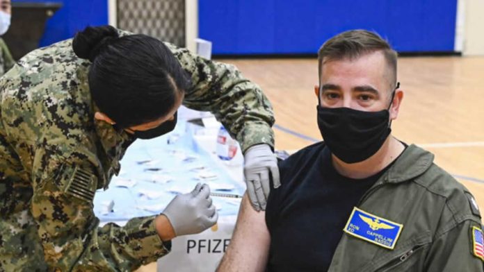 Um oficial da Marinha recebe um reforço de vacina COVID-19 durante um exercício de imunização em massa na Estação Aeronáutica de Sigonella, em 7 de dezembro de 2021. (Foto da Marinha dos EUA / Especialista em Comunicação em Massa de 2ª Classe Josh Cote)